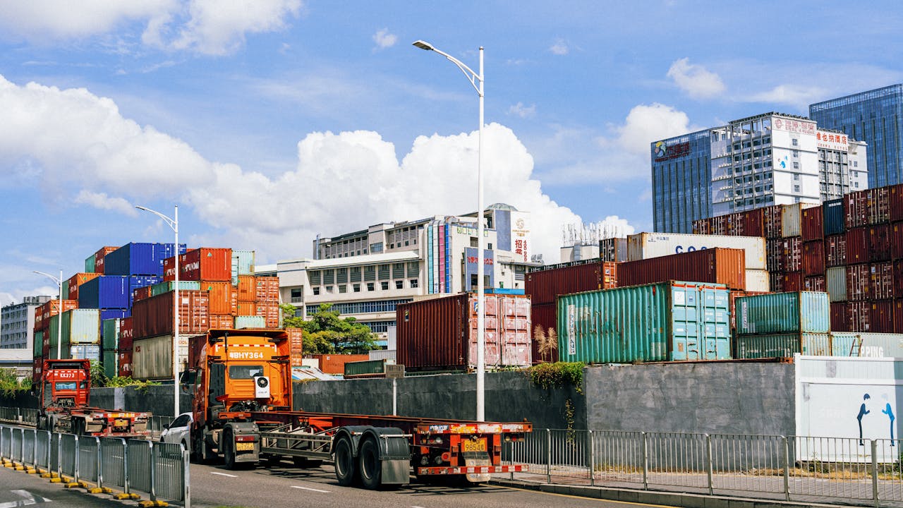 Colorful shipping containers stack at an industrial port under clear skies.
